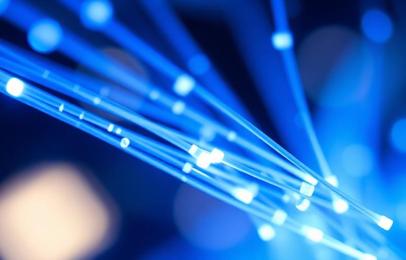 Cabos de fibra óptica com luz azul ilustrando a velocidade da internet fibra óptica da Jotazo Telecom
